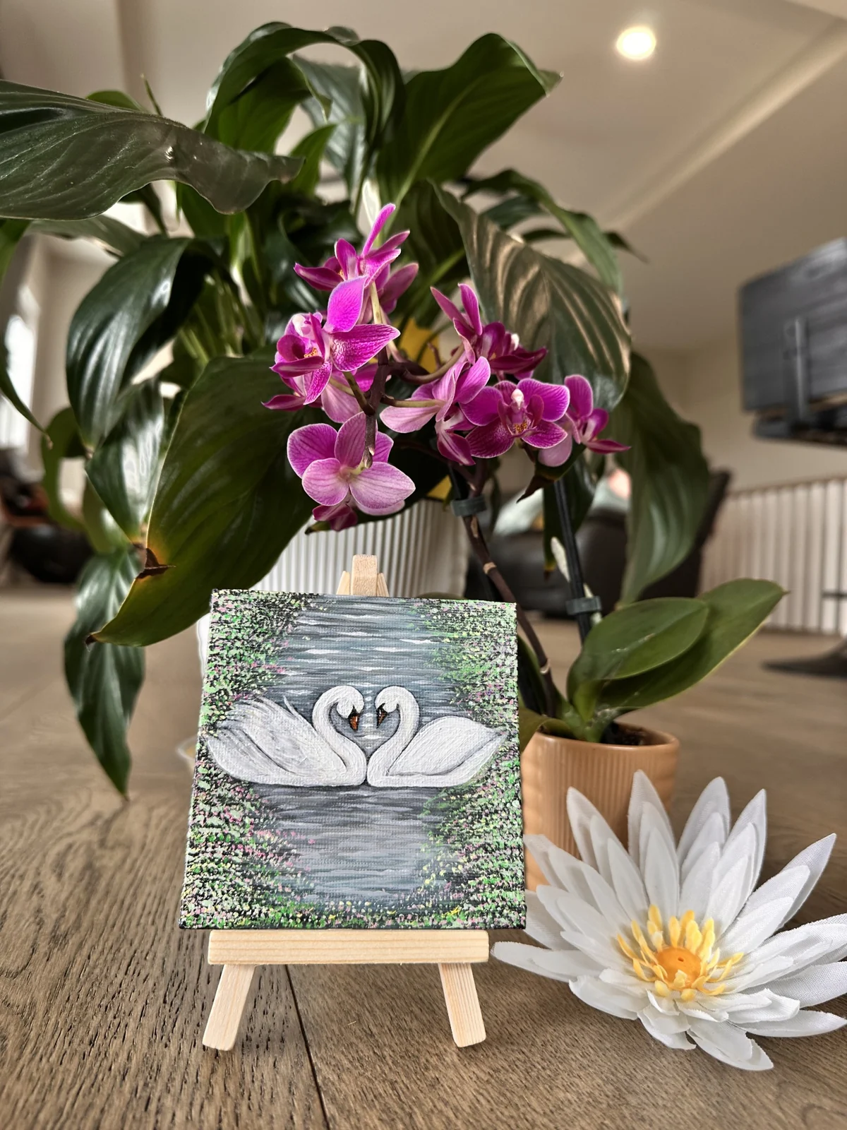 A miniature swan painting on a wooden easel